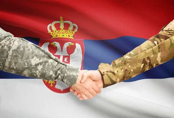 Men in uniform shaking hands with flag on background - Serbia — Stock Photo, Image