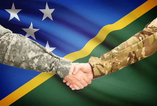 Hombres en uniforme de estrecharme la mano con la bandera en el fondo - Islas Salomón — Foto de Stock