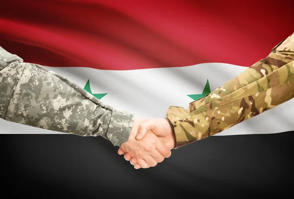 Men in uniform shaking hands with flag on background - Syria — Stock Photo, Image