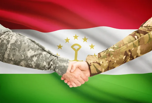 Люди в форме, пожимая руки с флагом на фоне - Таджикистан — стоковое фото