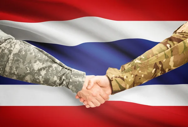 Hombres en uniforme de estrecharme la mano con la bandera en el fondo - Tailandia — Foto de Stock