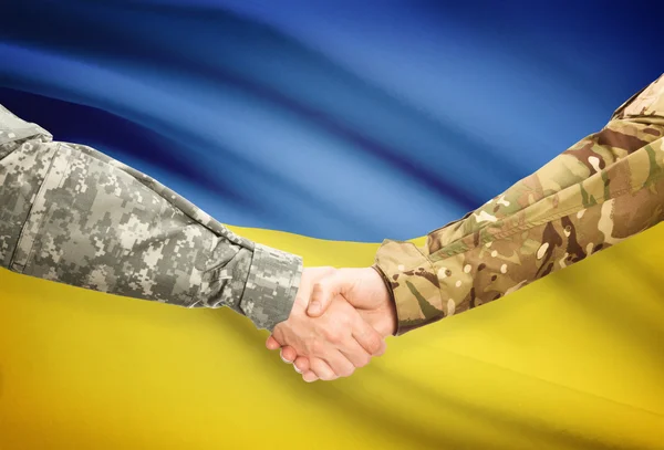 Men in uniform shaking hands with flag on background - Ukraine — Stock Photo, Image