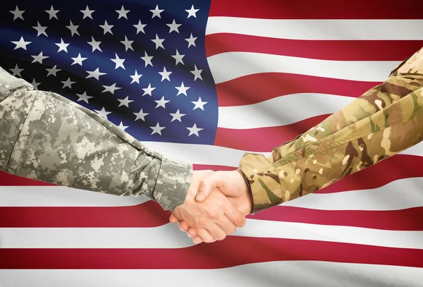 Чоловіки у військовій формі, потискує руку прапор на фоні - США — стокове фото