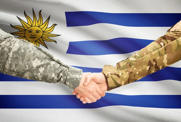 Hommes en uniforme se serrant la main avec le drapeau sur fond - Uruguay — Photo