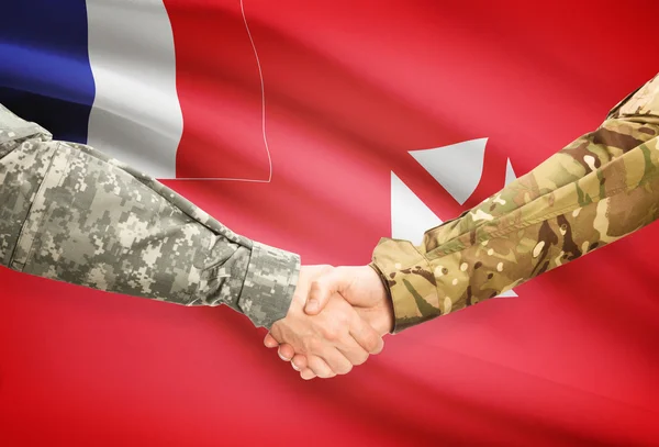 Men in uniform shaking hands with flag on background - Wallis and Futuna — Stock Photo, Image