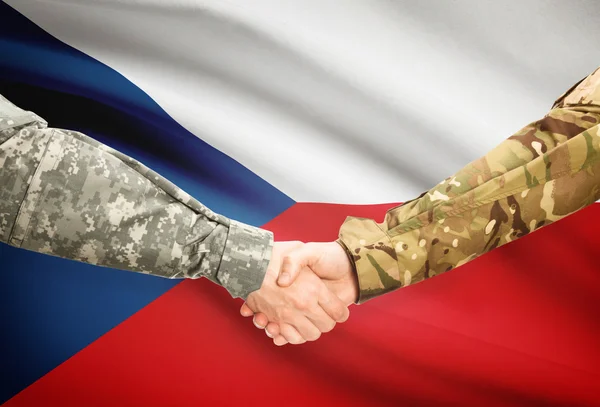 Hommes en uniforme se serrant la main avec le drapeau sur fond - République tchèque Image En Vente