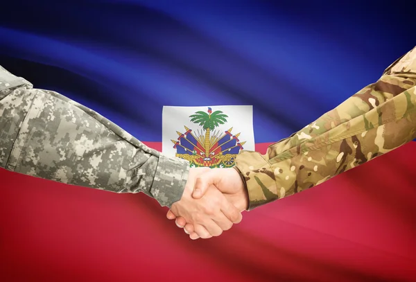 Mannen in uniform schudden handen met vlag op achtergrond - Haïti — Stockfoto