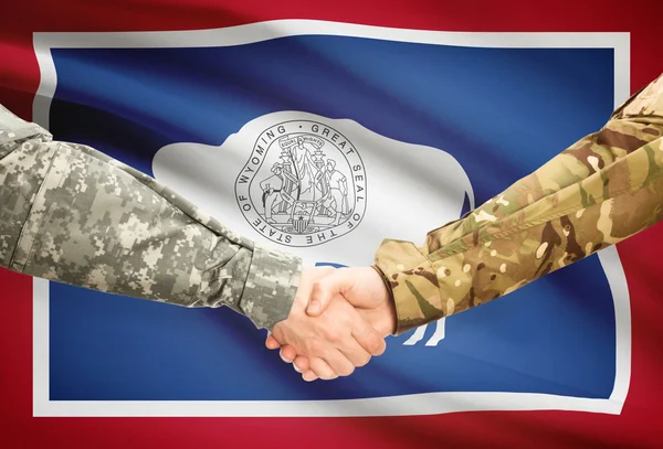 Militaire handdruk en ons staat vlag - Wyoming — Stockfoto