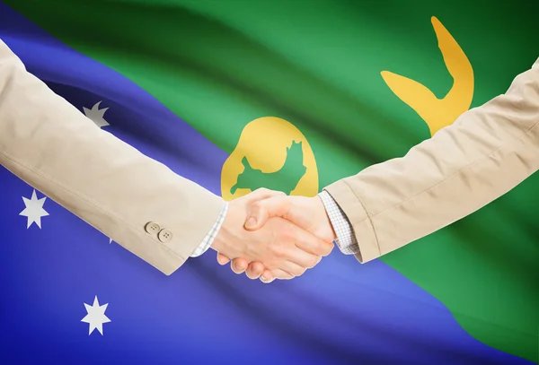 Üzletemberek kézfogás zászló a háttérben - Karácsony-sziget — Stock Fotó