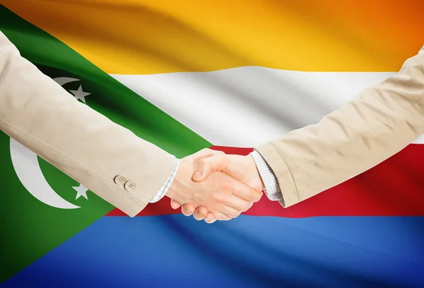 Businessmen handshake with flag on background - Comoros — Stock Photo, Image