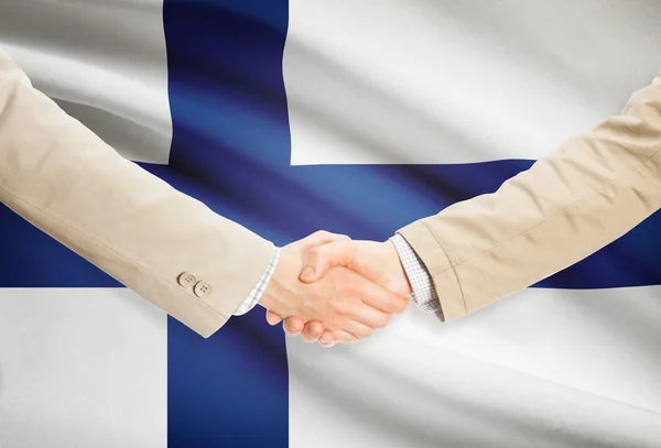 Apretón de manos de empresarios con bandera sobre fondo - Finlandia —  Fotos de Stock