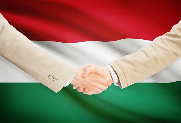 Unternehmer-Handshakes mit Flagge auf Hintergrund - Ungarn — Stockfoto