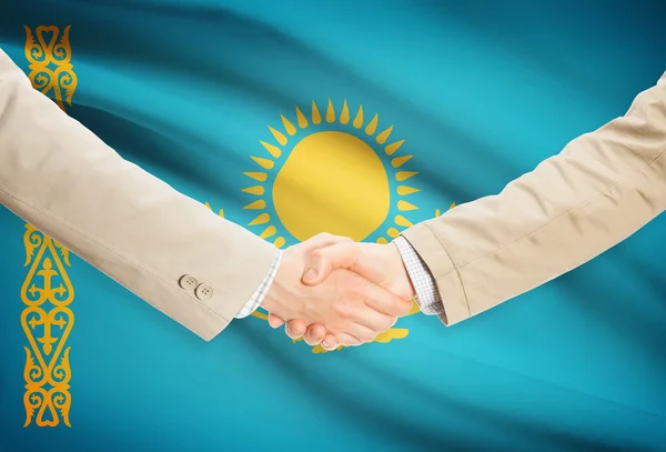 Businessmen handshake with flag on background - Kazakhstan – stockfoto