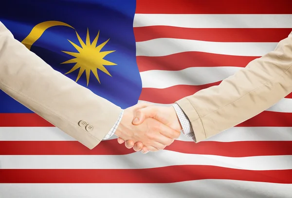 Businessmen handshake with flag on background - Malaysia — Stock Photo, Image