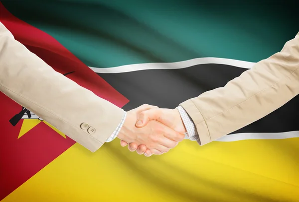 Businessmen handshake with flag on background - Mozambique — Stock Photo, Image