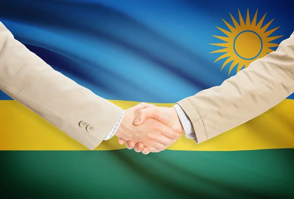 Apretón de manos de empresarios con bandera sobre fondo - Rwanda — Foto de Stock