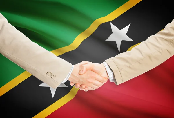 Businessmen handshake with flag on background - Saint Kitts and Nevis — Stock Photo, Image