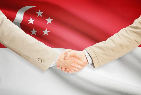 Affärsmän handslag med flagga på bakgrund - Singapore — Stockfoto