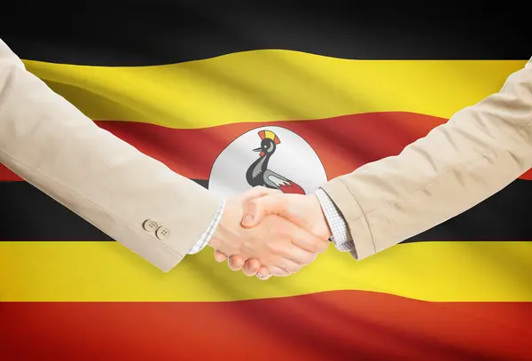 Unternehmer-Handshakes mit Flagge auf Hintergrund - Uganda — Stockfoto