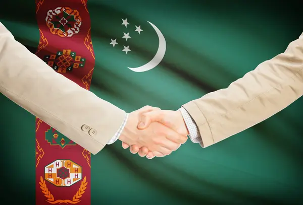 Apretón de manos de empresarios con bandera sobre fondo - Turkmenistán — Foto de Stock