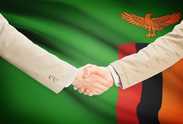 Apretón de manos de empresarios con bandera sobre fondo - Zambia —  Fotos de Stock