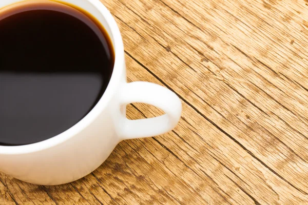 Taza de café negro en la mesa de madera vieja - vista desde arriba —  Fotos de Stock