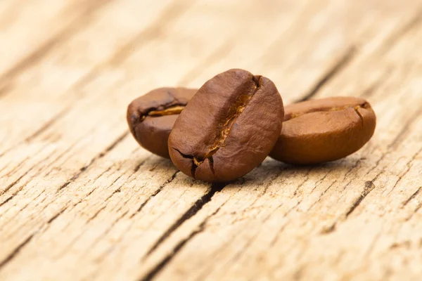 Coffee beans on wooden table - close up shot — Stock Photo, Image