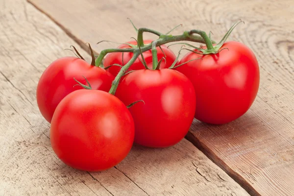 Bunch of red tomatoes on wooden table - studio shot — Stock Photo, Image