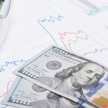 hesap makinesi ve 100 dolarlık banknot - hisse senedi grafiği yakın çekim