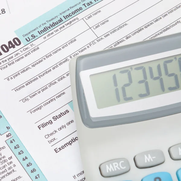 Calculator over US 1040 Tax Form - close up — Stock Photo, Image