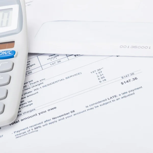 Calculator with utility bill under it - close up — Stock Photo, Image