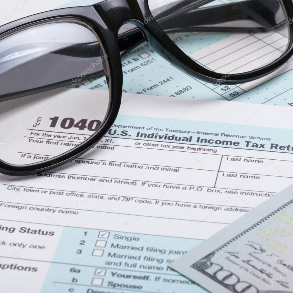 US 1040 Tax Form, glasses and dollars - close up shot