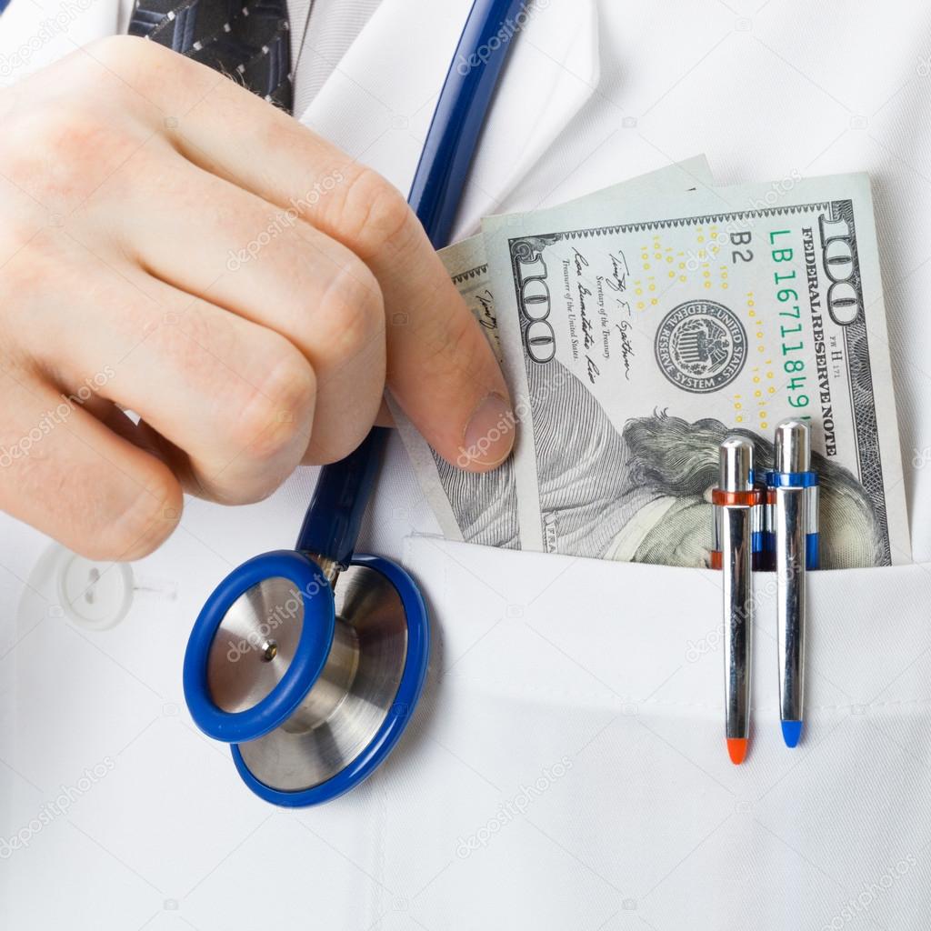 Medical doctor with US dollars in his pocket - close up