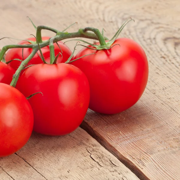 Bunch of fresh red tomatoes on wooden table - studio shot — Stock Photo, Image