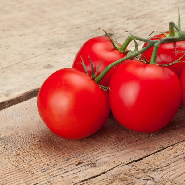 Red tomatoes over wooden table - studio shot — Stock Photo, Image