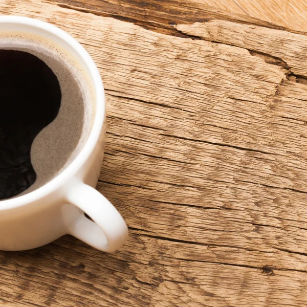 Zwarte koffie cup op oude houten tafel — Stockfoto
