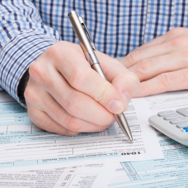 Taxpayer filling out 1040 Tax Form - close up clipart