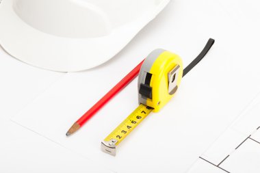 Measure tape, construction helmet and pencil