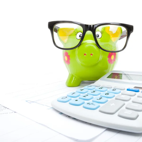 Market charts with piggy bank and calculator over it - close up — Stock Photo, Image