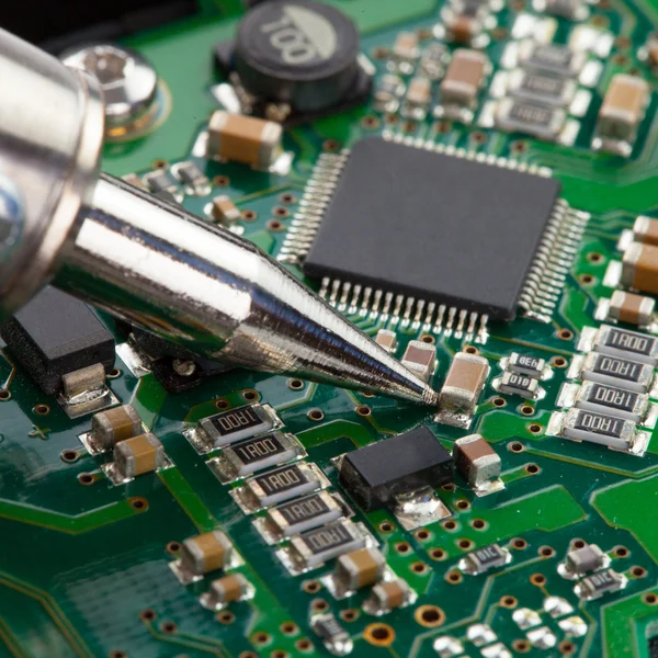 Soldering iron and microcircuit - close up — Stock Photo, Image