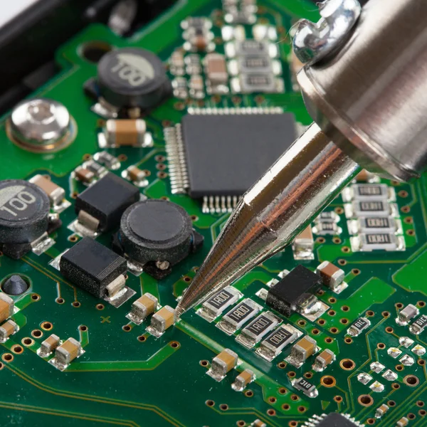 Soldering iron with microcircuit - close up — Stock Photo, Image