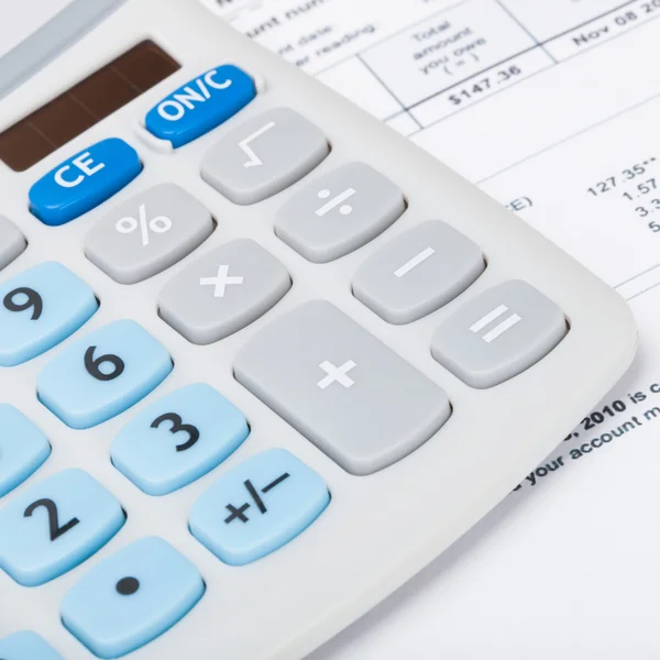 Calculator with utility bill under it - close up studio shot — Stock Photo, Image