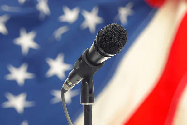 Microphone on stand with USA flag on background