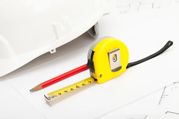 Yellow measure tape, pencil and construction helmet — Stockfoto