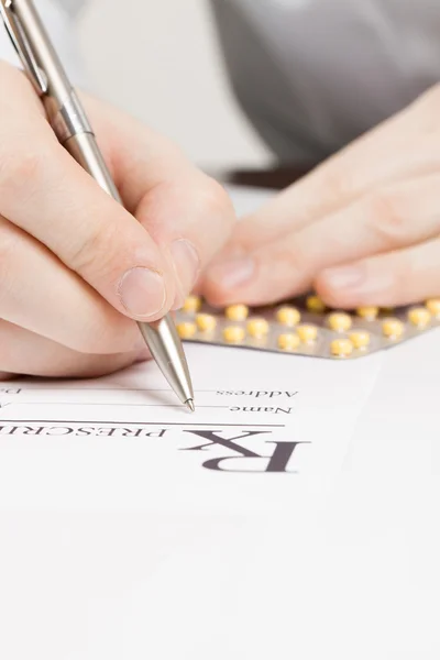 Medical doctor filling out drug prescription - studio shot — Stok fotoğraf