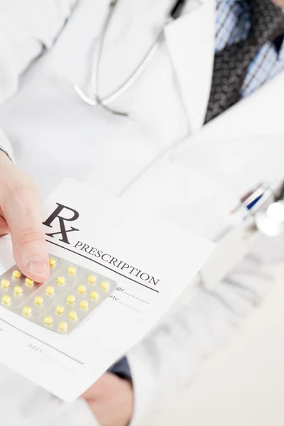 Medical doctor handing out drug prescription and pills - studio shot — Stock Photo, Image