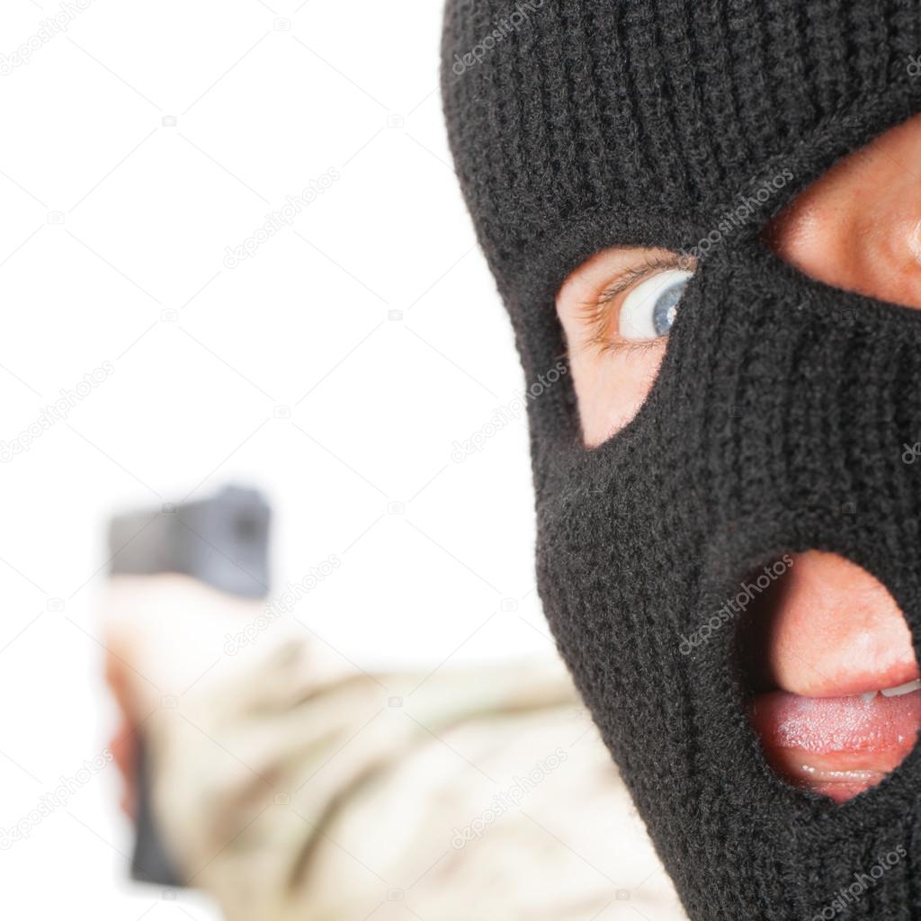 Crazy man in black mask holding gun - close up