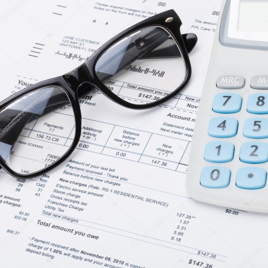 Calculator and glasses with utility bill under it - close up