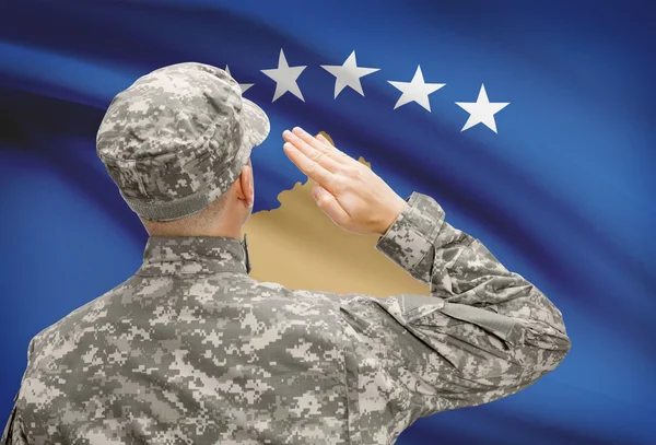 Katona, szemben a nemzeti zászló sorozat - koszovói kalapban — Stock Fotó