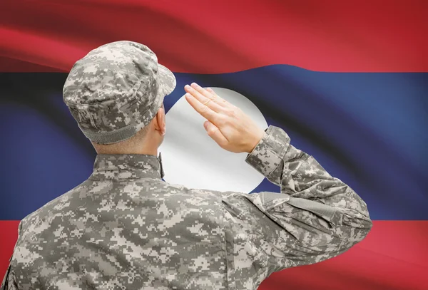 Voják v klobouku čelí řada státní vlajky - Laos — Stock fotografie